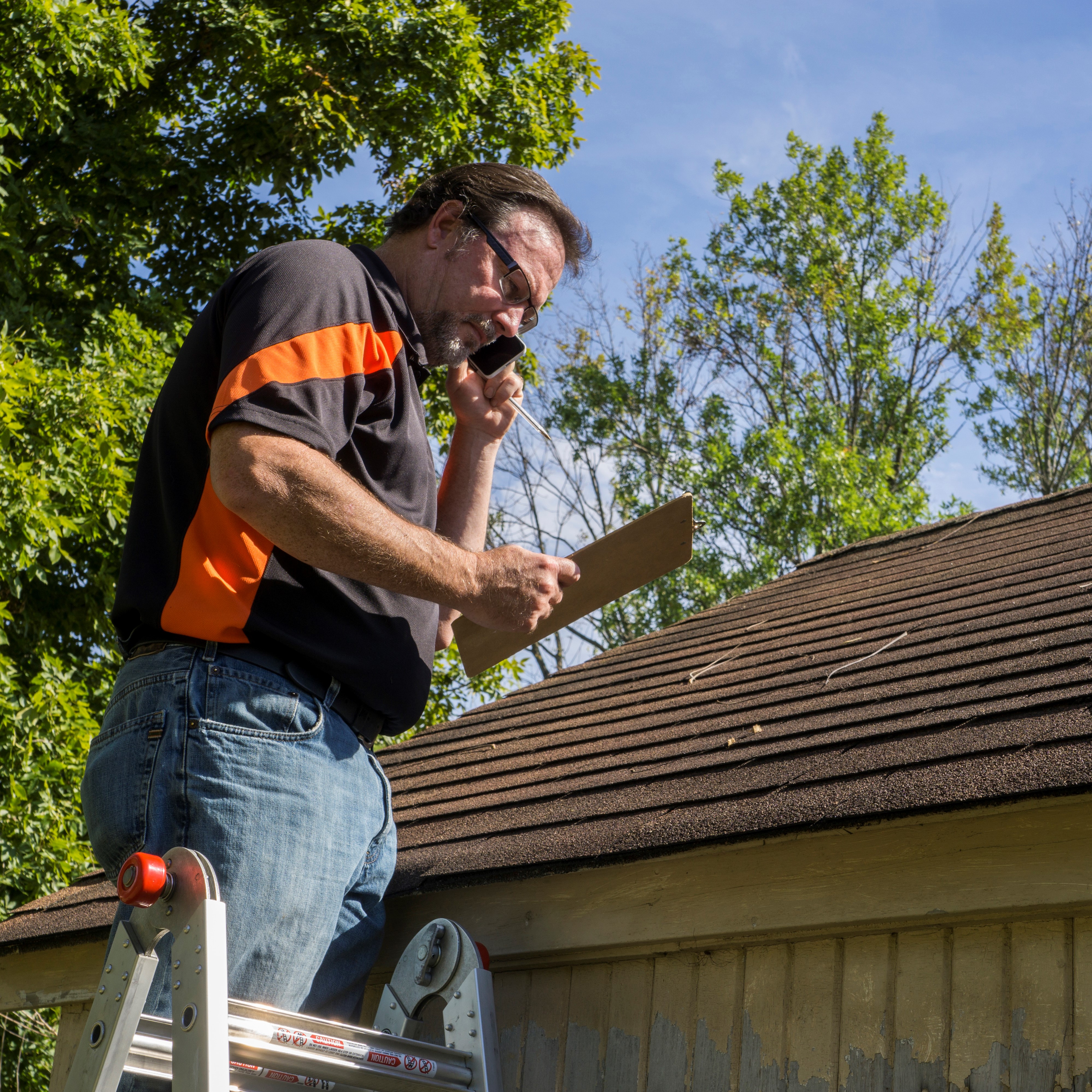 An Insurance Adjuster Inspects a Roof for Damage.